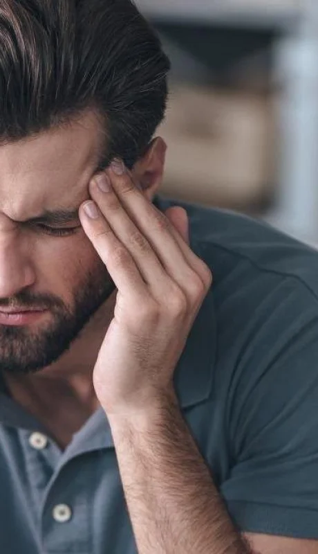 man-with-migraine-headache-massaging-his-temples-and-frowning-jpg.