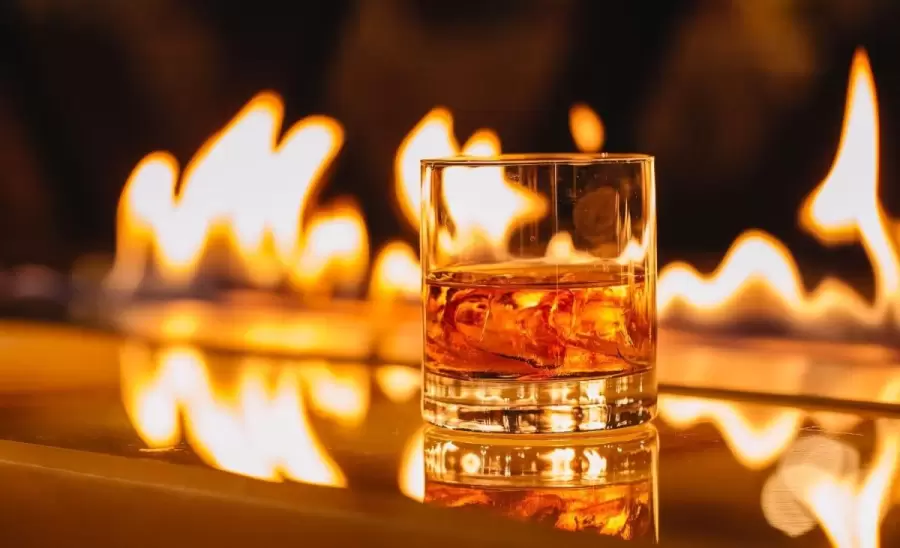 vista-lateral-vaso-whisky-hielo-sobre-fondo-llama-ardiente-jpg.