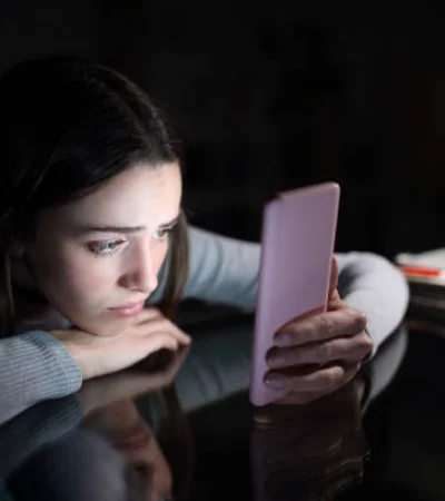 Persona mirando con tristeza su celular.