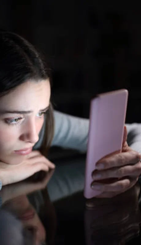 Persona mirando con tristeza su celular.