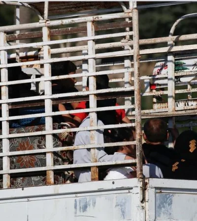 Familias con sus pocas pertenencias escapan de los bombardeos, en medio de un tráfico congestionado, hacia el norte del país.
