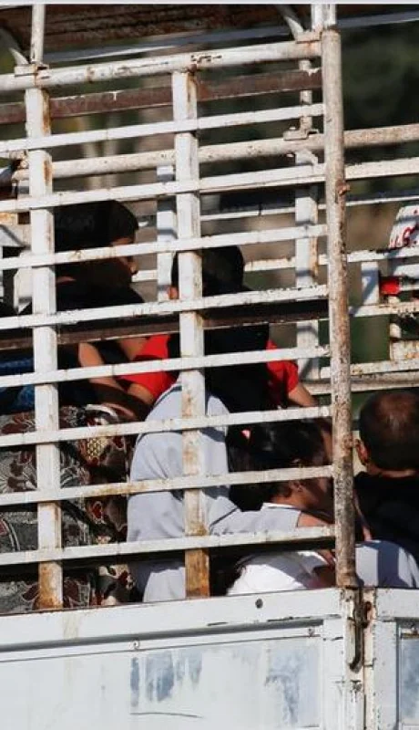 Familias con sus pocas pertenencias escapan de los bombardeos, en medio de un tráfico congestionado, hacia el norte del país.