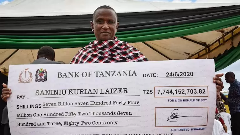 Saniniu Laizer con el cheque que le brindó el gobierno de Zambia.