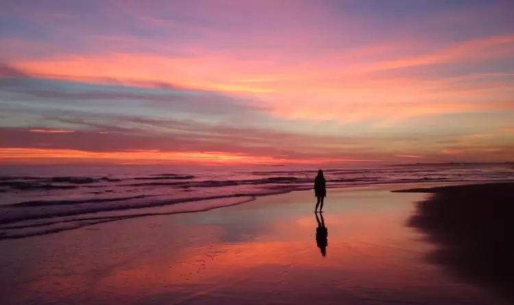 La playa de Reta invita a disfrutar de atardeceres que tiñen el cielo de naranja y rosa sobre el mar.