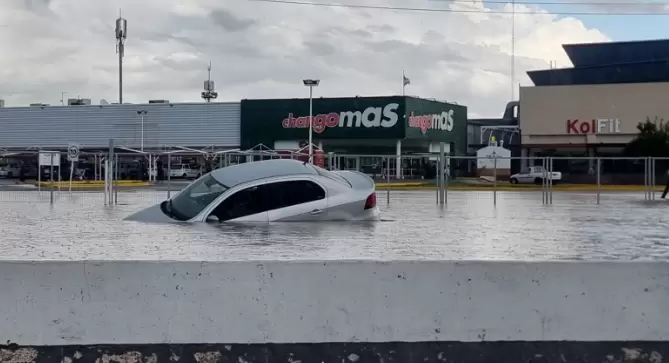Un automóvil quedó hundido en el agua que se estancó rápidamente frente a un supermercado en la intersección de las calles Maza y Mitre.