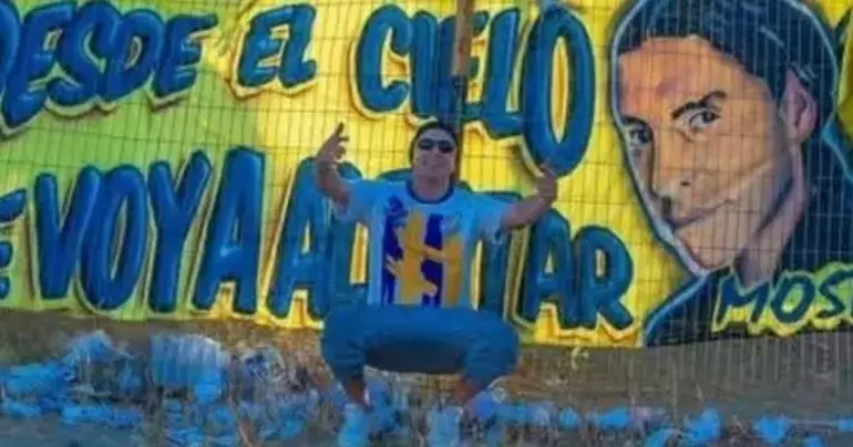 Ramiro Martínez ante un mural de su equipo favorito, Oeste Juniors de Comodoro Rivadavia.