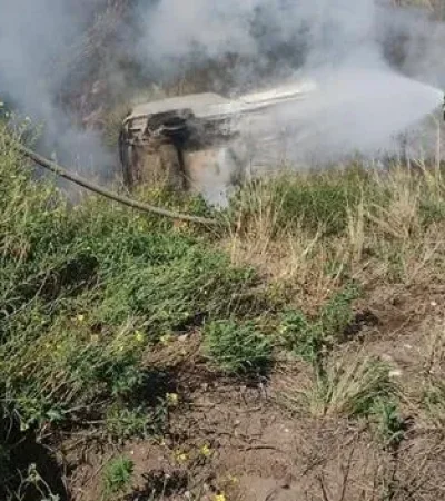 Los bomberos tratan de apagar el incendio del auto, con las dos víctimas fatales en su interior. (Foto: gentileza El Diario)