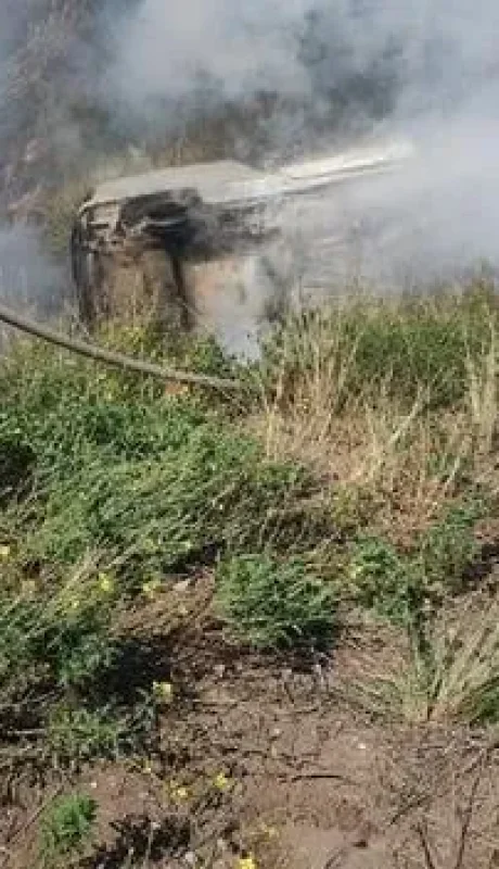 Los bomberos tratan de apagar el incendio del auto, con las dos víctimas fatales en su interior. (Foto: gentileza El Diario)