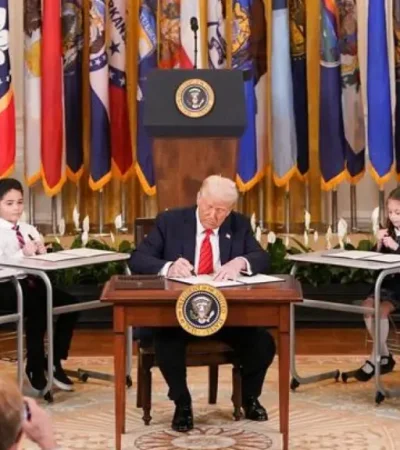 Trump rubricó el decreto rodeado de 12 niños sentados en sus pupitres.