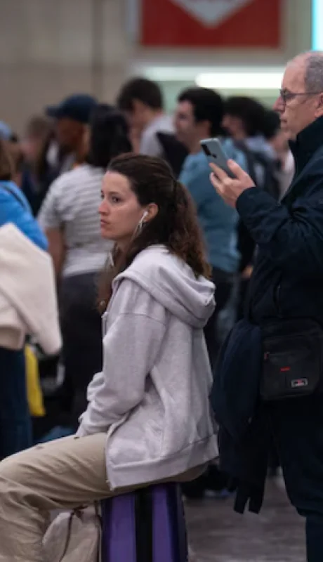 Varias personas esperan en la estación de Sants tras el apagón eléctrico, 29 de abril de 2025, en Barcelona, Cataluña (España).