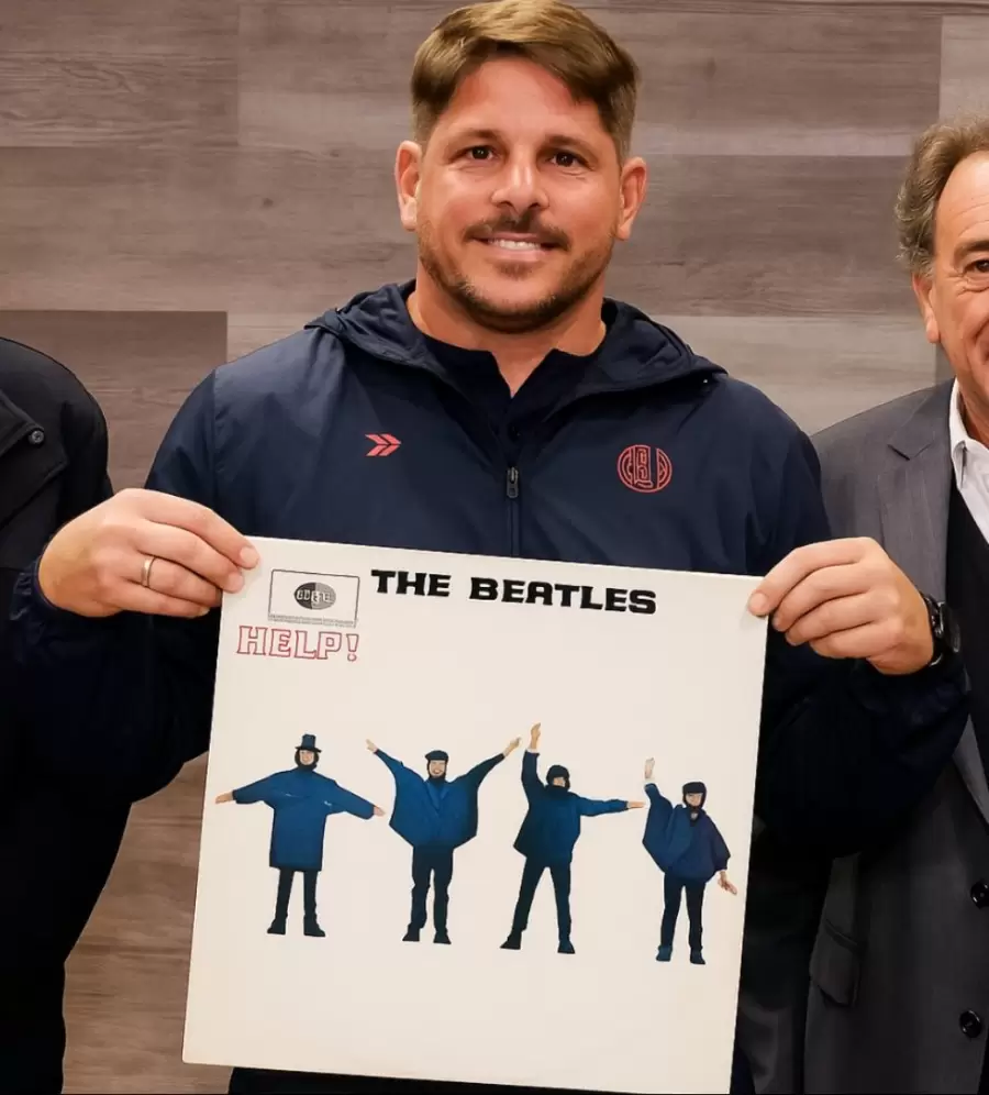 Un meme del nuevo entrenador sosteniendo la tapa de un disco de The Beatles "Help"