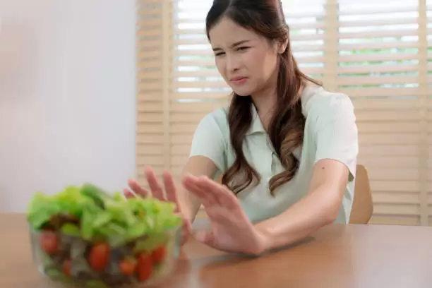 Persona mira con asco su comida.