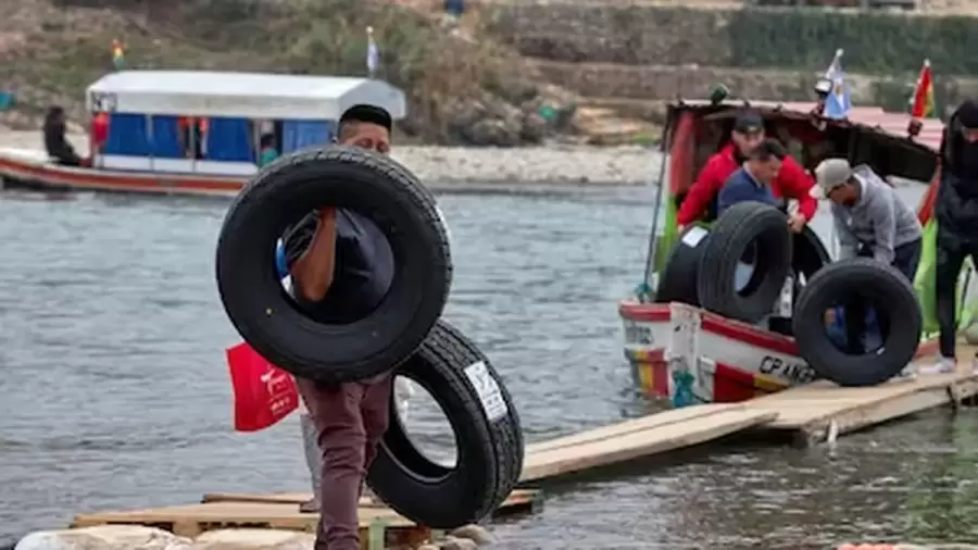 Los precios de los neumáticos sí son para considerar. En la imagen, un argentino cruza en balsa la frontera.