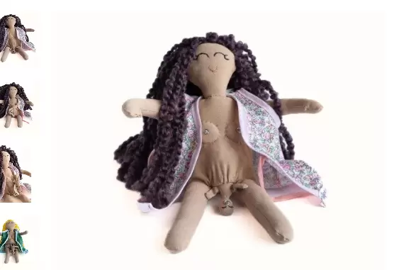 La muñeca embarazada de tela confeccionada artesanalmente, incluye un bebé en su vientre, que se prende por medio de un broche a la teta de la madre.