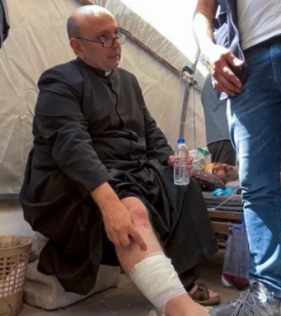 El padre argentino Gabriele Romanelli luego de haber recibido asistencia médica tras el ataque israelí.