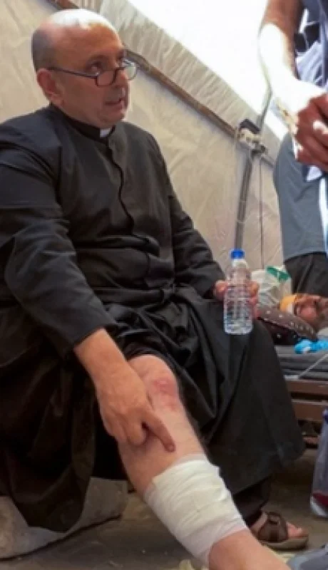 El padre argentino Gabriele Romanelli luego de haber recibido asistencia médica tras el ataque israelí.