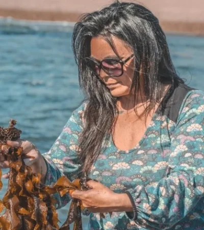 Carola Puracchio eligiendo algas invasoras que llegaron en barco a la costa patagónica y ahora ella las transforma en exóticos platos.