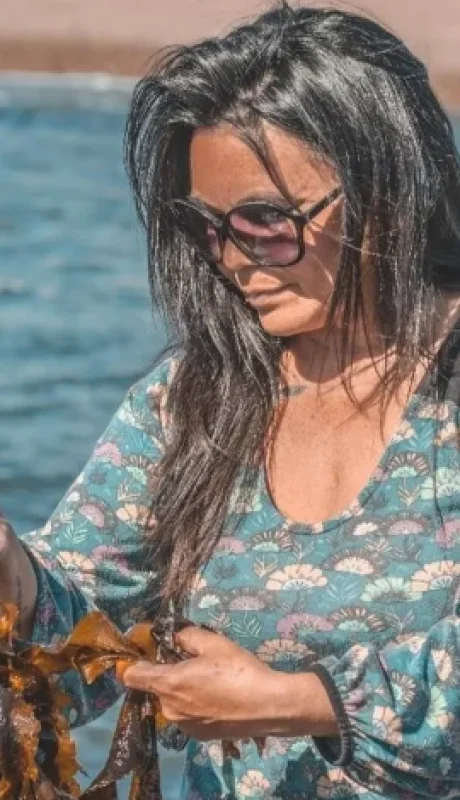 Carola Puracchio eligiendo algas invasoras que llegaron en barco a la costa patagónica y ahora ella las transforma en exóticos platos.