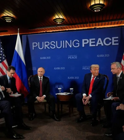 Putin y Trump dialogan secundados por sus respectivas delegaciones.