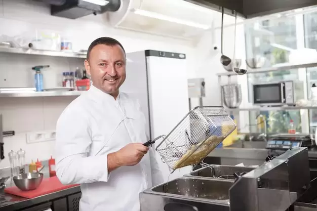 Un cocinero feliz. Lógico, está cocinando papas fritas.