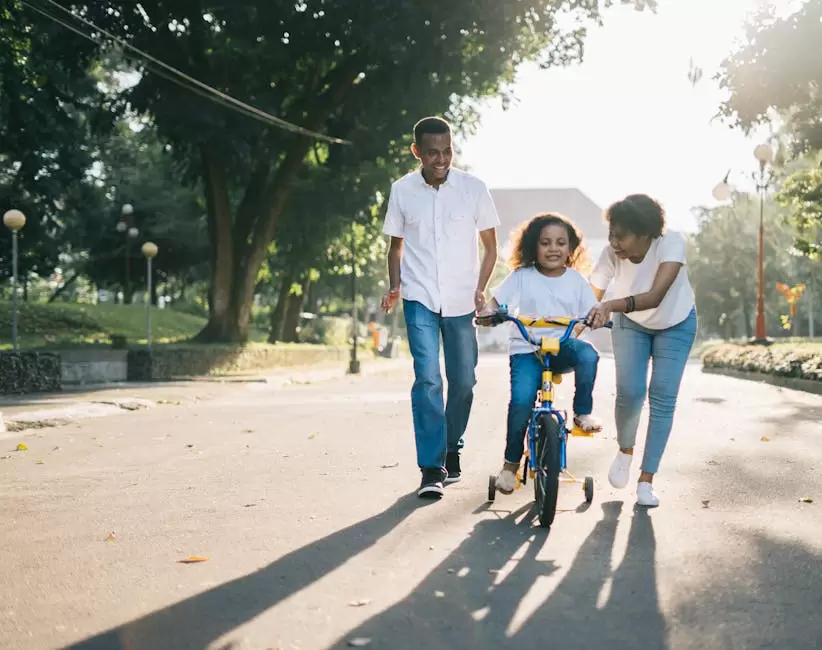 Hombre De Pie Junto A Su Esposa Enseñando A Su Hijo A Andar En Bicicleta