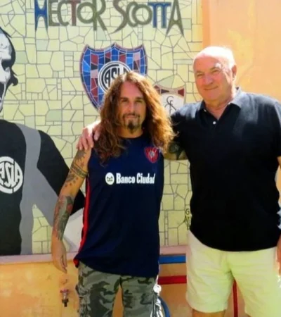 Héctor Scotta junto al historiador cuervo Victor Pradel, en un mural en la entrada de su casa junto a unos asientos del Viejo Gasómetro.