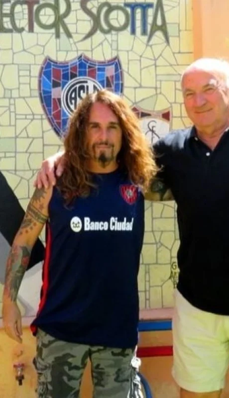 Héctor Scotta junto al historiador cuervo Victor Pradel, en un mural en la entrada de su casa junto a unos asientos del Viejo Gasómetro.