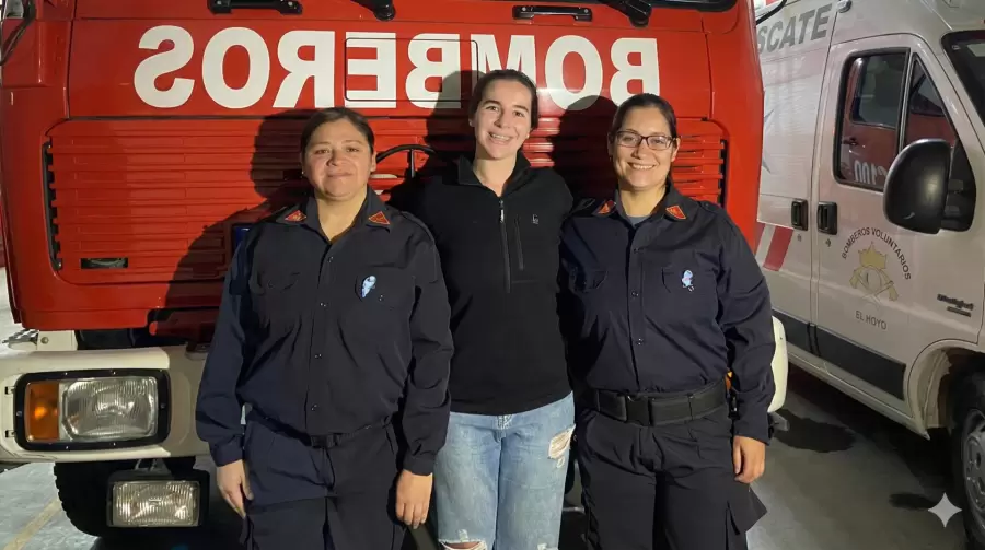 Sofía Cerella, presidenta de Bomberos Voluntarios de El Hoyo, junto a dos compañeras.