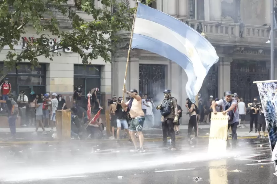 Manifestantes enfrentan a un vehículo lanza agua